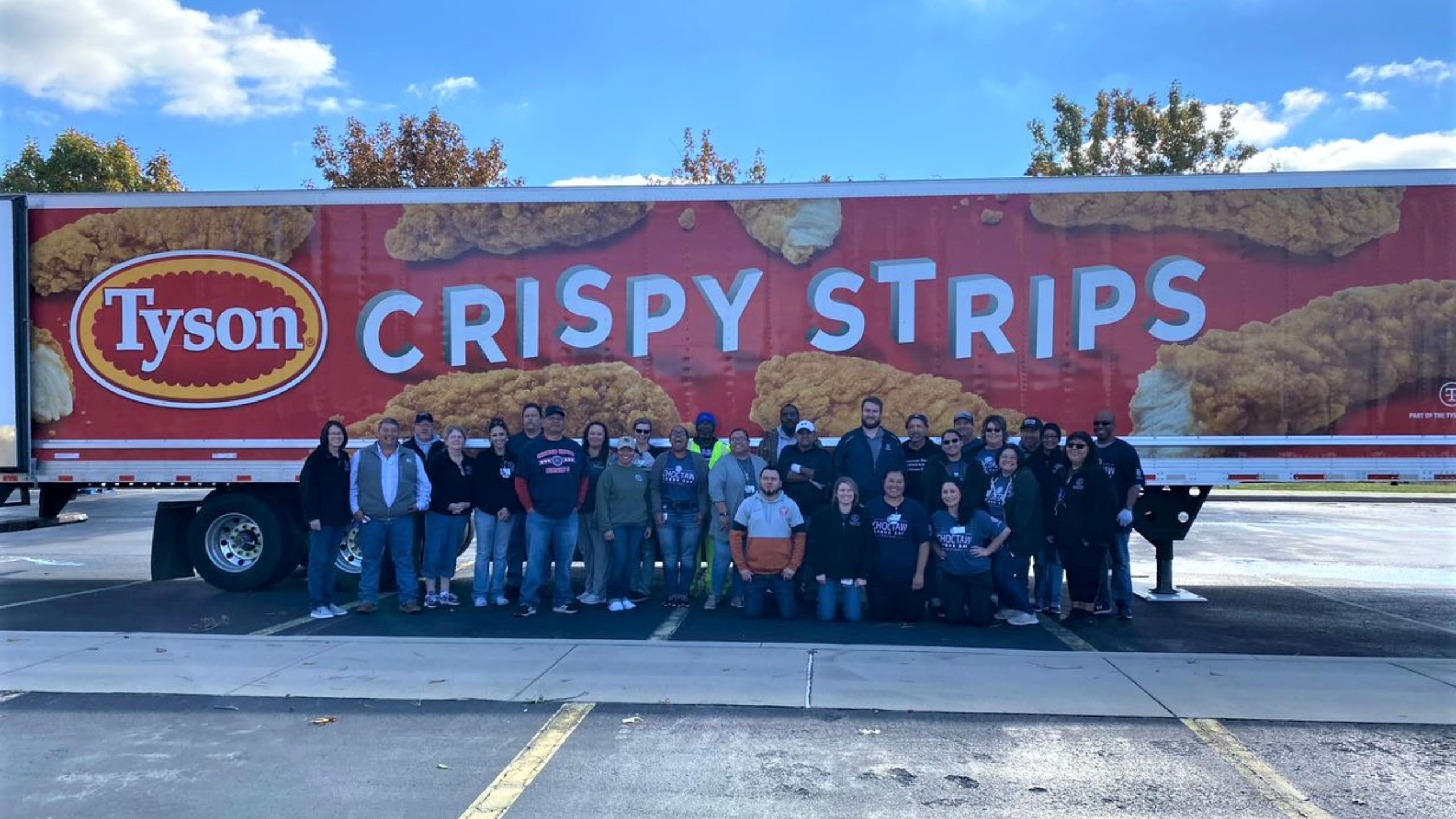 This is a group of people standing in front of a Tyson truck.